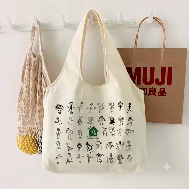 Natural canvas tote bag printed with every child's own self-portrait drawing and the school logo